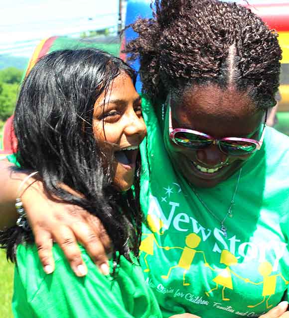 A student and support staff hug at their special needs school picnic.