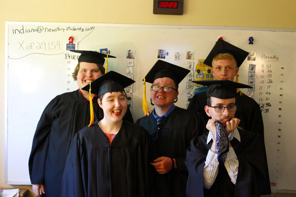 Five special needs students smile in their caps and gowns for graduation.