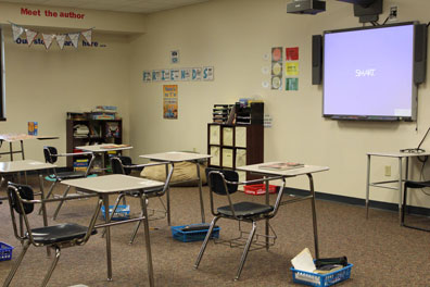 An autism support classroom with desks facing a smart board