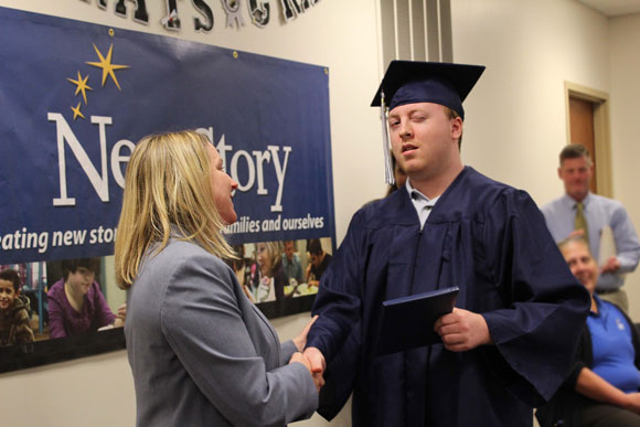 A high school student smiles at the camera during his special education graduation.
