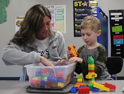 A special education student works on a project with his instructor.