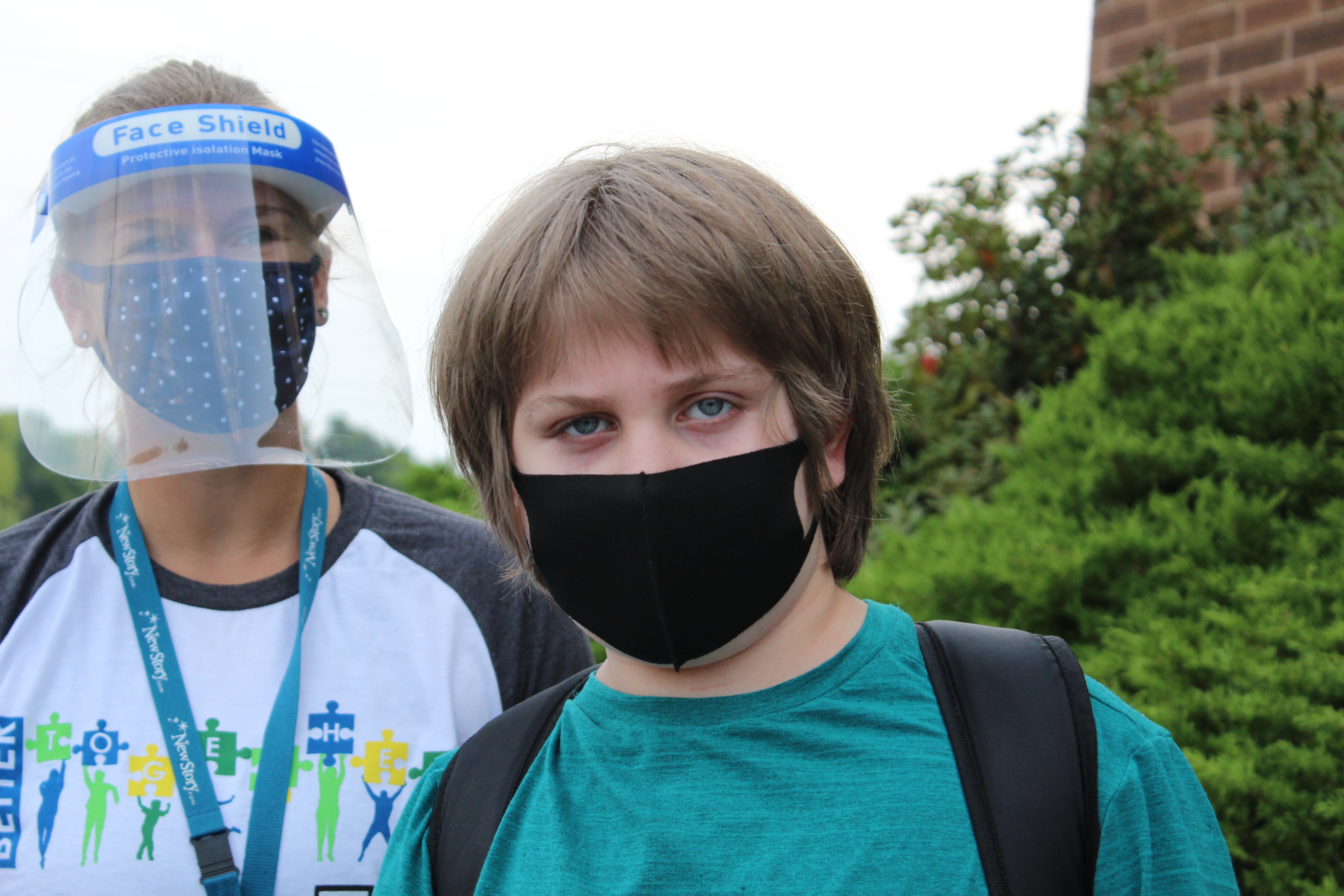 Special Education Student in mask outside, Teacher with face guard and mask.