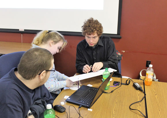 Three high school aged students work together at an event sponsored by their private special education school.